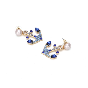 Detailed shot of anchor earrings featuring gradient blue rhinestones and a white pearl