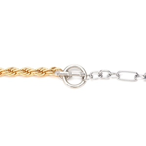Close-up of dual-tone chunky chain necklace with gold twist link and silver OT toggle clasp