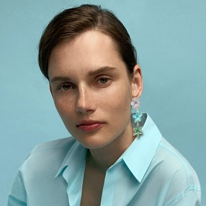 Elegant floral drop earrings with purple blue and green enamel flowers on female model
