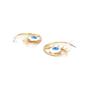 Détail macro des boucles d'oreilles Evil Eye dorées avec émail bleu et cils