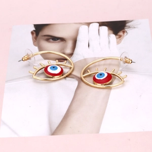 Vue détaillée de boucles d'oreilles œil porte-bonheur dorées avec émail coloré