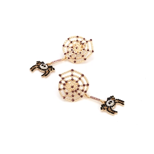 Macro detail of Halloween spider web earrings with purple crystals and gold alloy base