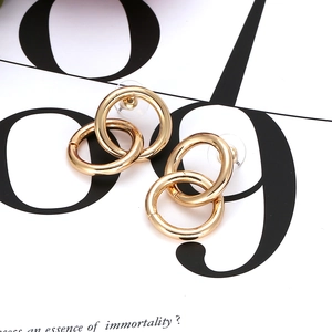 Minimalist gold-plated interlocking double circle hoop earrings on a fashion magazine