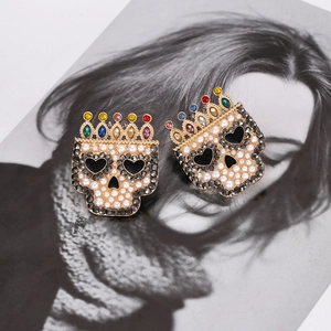 Baroque pearl skull earrings with colorful crown and heart eyes on fashion magazine