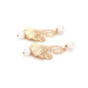 Elegante gouden ginkgo blad oorbellen met witte parels en bionische texturen op wit