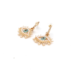 Détails des boucles d'oreilles œil avec cristaux bleus, perles et cils dorés brillants