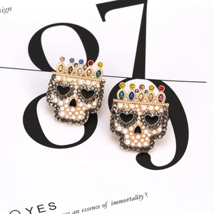 Detailed shot of baroque skull earrings with pearls, crystals and a colorful crown