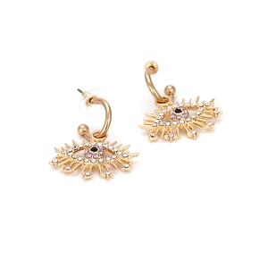 Vue détaillée des boucles d'oreilles œil porte-bonheur dorées avec cristaux violets et noirs
