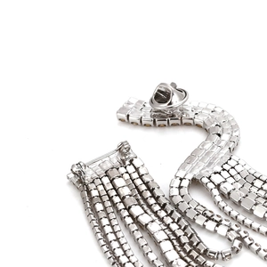 Vue macro d'une broche à franges argentées avec détails en strass étincelants