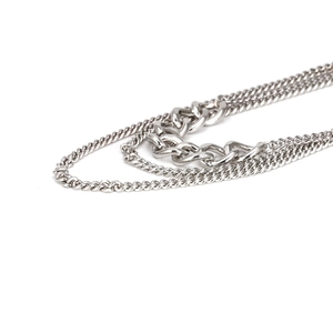 Close-up of multi-layer silver metal chain necklaces with various link textures