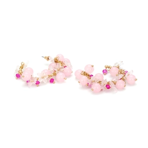 Dettaglio di orecchini a cerchio con perline rosa e fiori in resina fatti a mano e cristalli