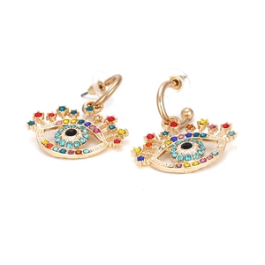 Détail macro de boucles d'oreilles œil maléfique avec strass colorés et base dorée