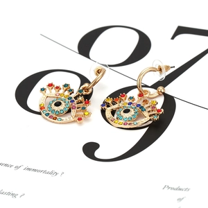 Boucles d'oreilles œil porte-bonheur dorées avec strass colorés et cils, vue de face
