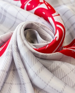 Detail of checkered silk scarf with red heart prints showing smooth fabric texture