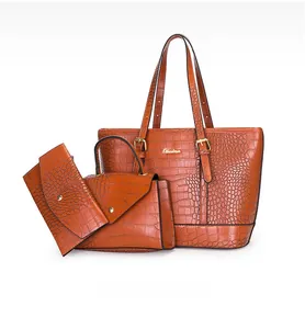 Detailansicht des 3-in-1-Taschensets aus braunem Krokodilleder mit goldenen Beschlägen