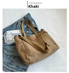 Khaki canvas tote bag with adjustable shoulder strap and leather brand label detail