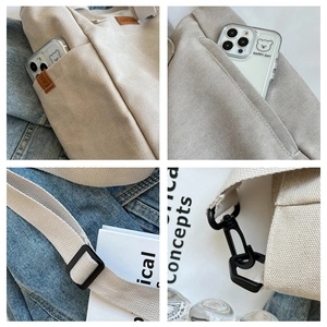 Detail view of canvas tote bag featuring side pockets, leather tag and adjustable strap
