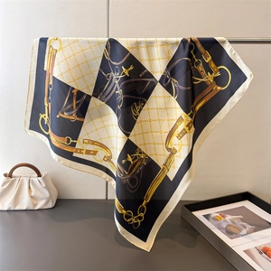 Detail of luxury silk scarf showing equestrian chain print and elegant drape texture