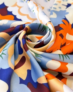Makroaufnahme eines Seidenschals mit abstraktem Blumendruck und luxuriöser Satin-Textur
