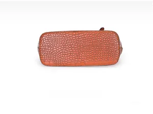 Detailansicht des Taschenbodens mit orangefarbener Krokoprägung aus Kunstleder