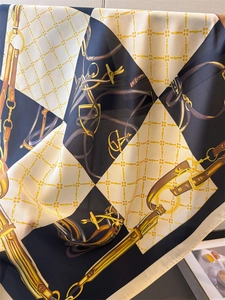 Close-up of navy and cream silk scarf featuring vintage equestrian horsebit patterns