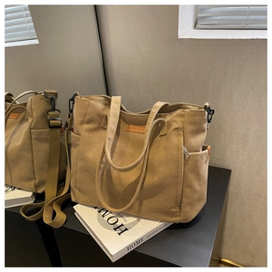 Detail view of khaki canvas tote bag featuring EARE LIFE logo and adjustable shoulder strap