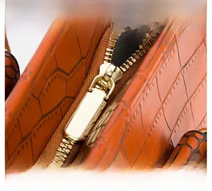 Detail des glatten Goldreißverschlusses und feiner Nähte an der Krokodil-Handtasche