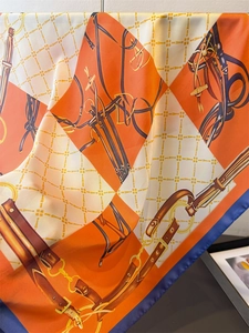 Detail of luxury silk scarf with vintage equestrian chain print in orange and blue
