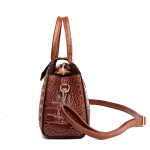 Brown crocodile embossed tote bag with top handle and detachable strap on white background