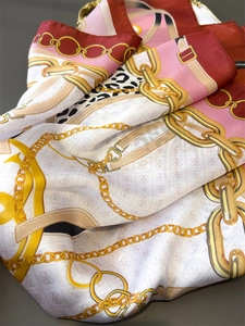 Detailed close-up of silk scarf with luxury chain prints and leopard pattern