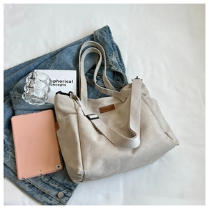 Detailed close-up of beige canvas tote bag showing textured fabric and brown EARE LIFE label