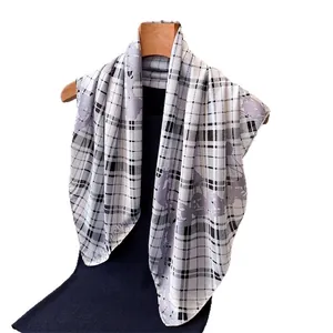 Elegant plaid chain print silk scarf with horse patterns on a wooden hanger