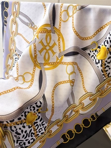 Detail of silk scarf with chain pattern and leopard print texture in soft folds