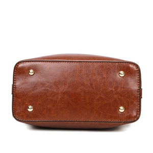 Large dark brown tote bag base view showing PU leather texture and gold protective studs