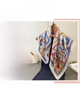 Detail of silk-like scarf featuring vintage gold chain and rope patterns in navy and red