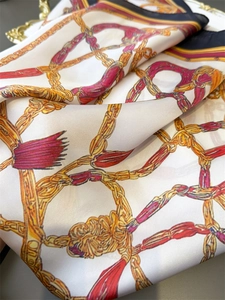 Close-up of vintage chain print silk scarf with golden chains and burgundy tassels