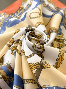 Close-up of luxury vintage faux silk scarf with classic horse harness and buckle patterns