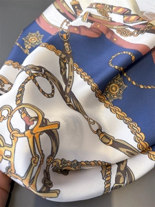 Detail of satin scarf with nautical gold chain print and smooth silk texture