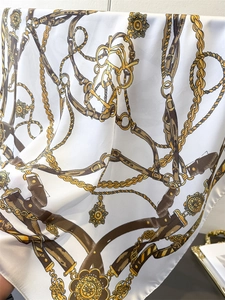 Detail of luxury silk scarf with vintage chain and equestrian crown print patterns