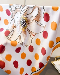 Gros plan d'imprimés floraux et de pois sur un foulard en soie synthétique haut de gamme