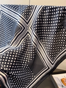 Nahaufnahme eines Seidenschals mit Punktmuster, Satin-Textur und feiner Verarbeitung