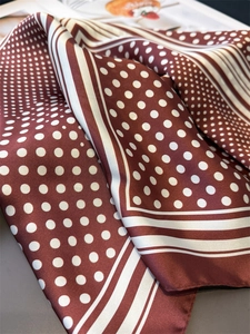 Detailansicht eines gepunkteten Seidentuchs mit eleganter Stoffstruktur auf einem Tisch