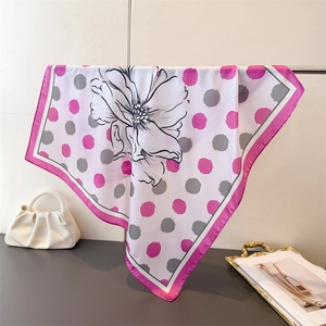 Vue détaillée d'un foulard en soie blanche avec pois roses et motifs floraux élégants