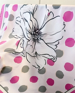 Détail de l'imprimé floral et à pois sur le foulard en satin au fini soyeux