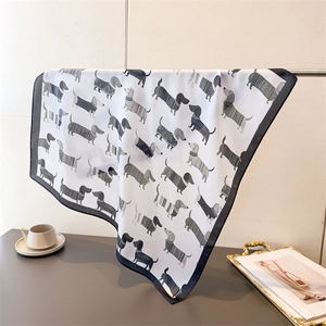 Détail d'un foulard en soie à imprimé teckel montrant des drapés doux et une texture chic
