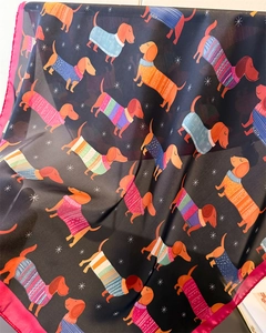 Détail d'un foulard en soie avec motifs de teckels colorés et bordures en soie rose