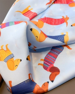 Détail d'un foulard en soie bleu clair orné de teckels colorés avec des plis élégants