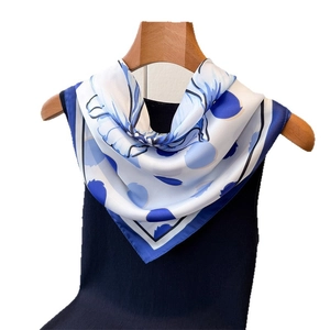 Foulard en satin à fleurs et pois sur cintre en bois avec un pull en tricot noir