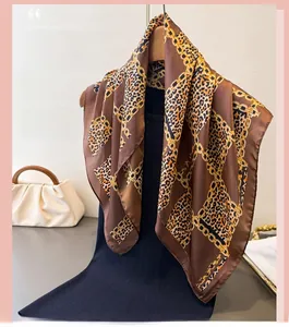 Close-up of leopard and gold chain print scarf with satin gloss on a black dress