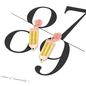 Boucles d'oreilles crayon mignonnes avec strass jaunes et perles sur carton blanc